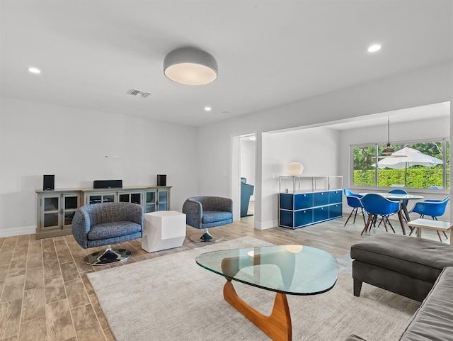 living room featuring wood finished floors, recessed lighting, baseboards, and visible vents