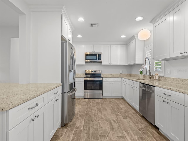kitchen featuring recessed lighting, stainless steel appliances, a sink, light wood-style floors, and visible vents