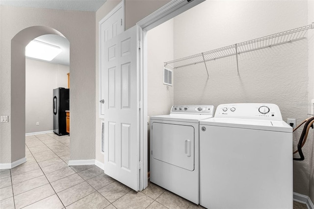 3314 Robert Trent Jones Dr Unit 308, Orlando, FL 32835 - washroom with light tile patterned floors, visible vents, independent washer and dryer, laundry area, and arched walkways