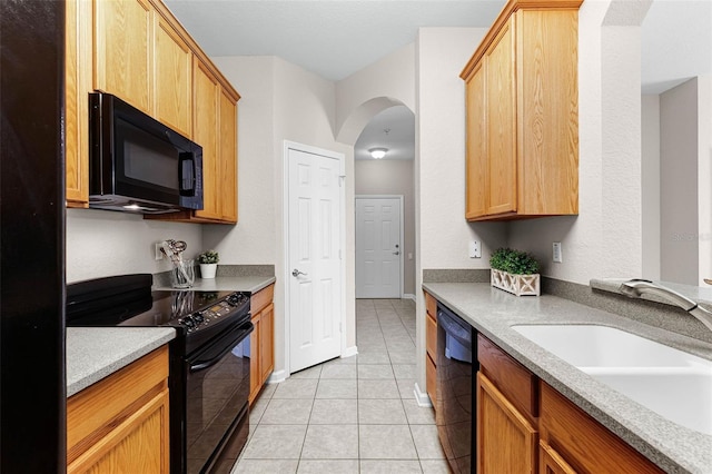3314 Robert Trent Jones Dr Unit 308, Orlando, FL 32835 - kitchen with arched walkways, a sink, light countertops, black appliances, and light tile patterned flooring
