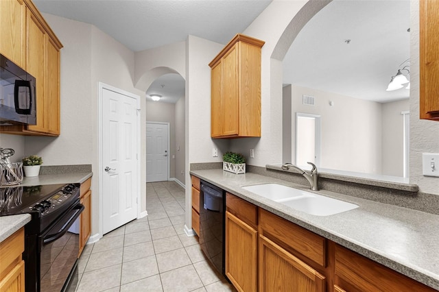 3314 Robert Trent Jones Dr Unit 308, Orlando, FL 32835 - kitchen with arched walkways, light tile patterned floors, a sink, and black appliances