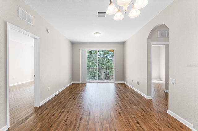 3314 Robert Trent Jones Dr Unit 308, Orlando, FL 32835 - empty room featuring visible vents, arched walkways, an inviting chandelier, and wood finished floors