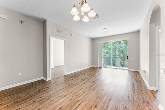 3314 Robert Trent Jones Dr Unit 308, Orlando, FL 32835 - empty room featuring a chandelier, wood finished floors, baseboards, and visible vents