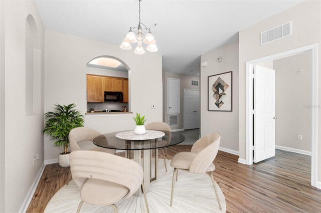3314 Robert Trent Jones Dr Unit 308, Orlando, FL 32835 - dining space with arched walkways, light wood finished floors, baseboards, and visible vents