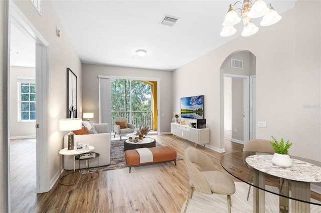 3314 Robert Trent Jones Dr Unit 308, Orlando, FL 32835 - living room with plenty of natural light, arched walkways, visible vents, and wood finished floors