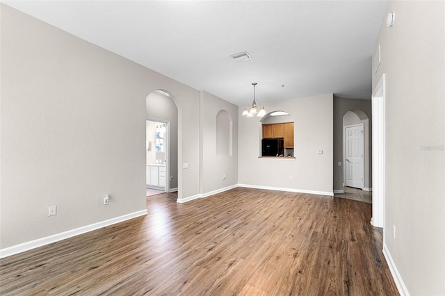 3314 Robert Trent Jones Dr Unit 308, Orlando, FL 32835 - unfurnished living room featuring visible vents, arched walkways, and wood finished floors