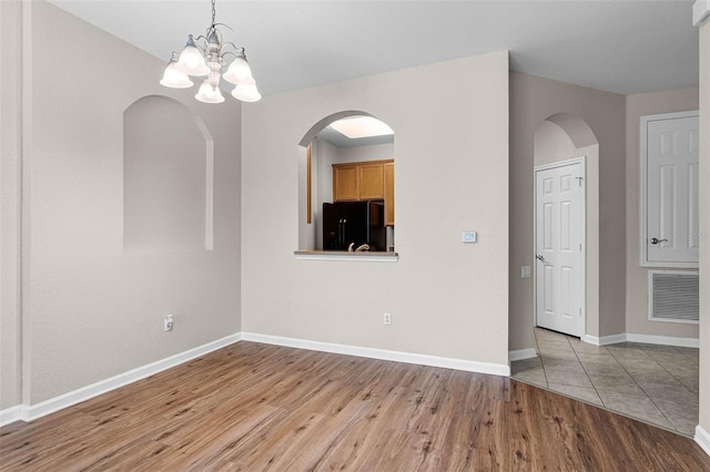 3314 Robert Trent Jones Dr Unit 308, Orlando, FL 32835 - interior space with visible vents, baseboards, arched walkways, a notable chandelier, and wood finished floors
