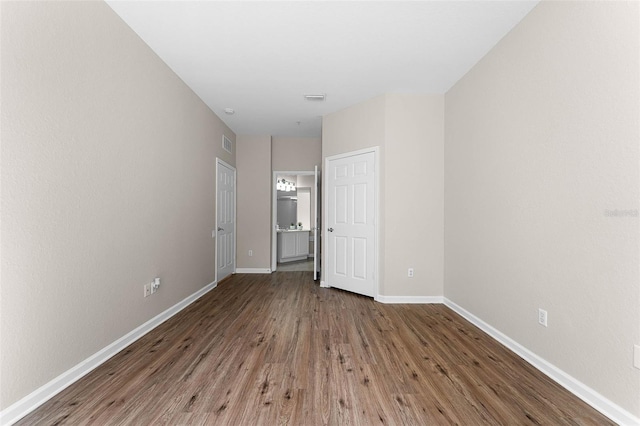 3314 Robert Trent Jones Dr Unit 308, Orlando, FL 32835 - unfurnished bedroom featuring visible vents, baseboards, ensuite bathroom, and wood finished floors