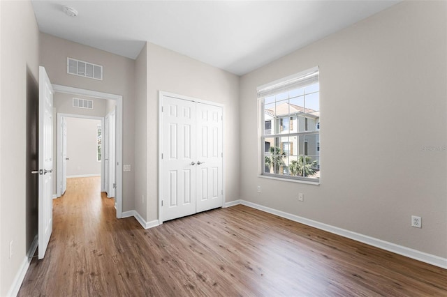 3314 Robert Trent Jones Dr Unit 308, Orlando, FL 32835 - unfurnished bedroom with wood finished floors, baseboards, a closet, and visible vents