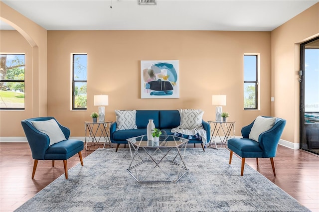 living area with a wealth of natural light, wood finished floors, and baseboards