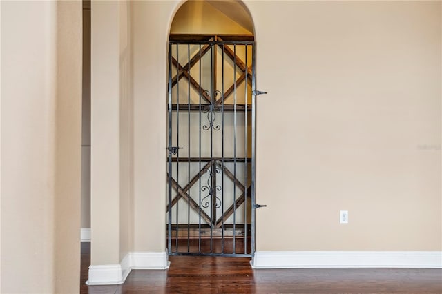 details featuring baseboards, arched walkways, and wood finished floors