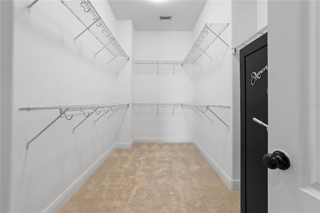 spacious closet featuring light colored carpet and visible vents