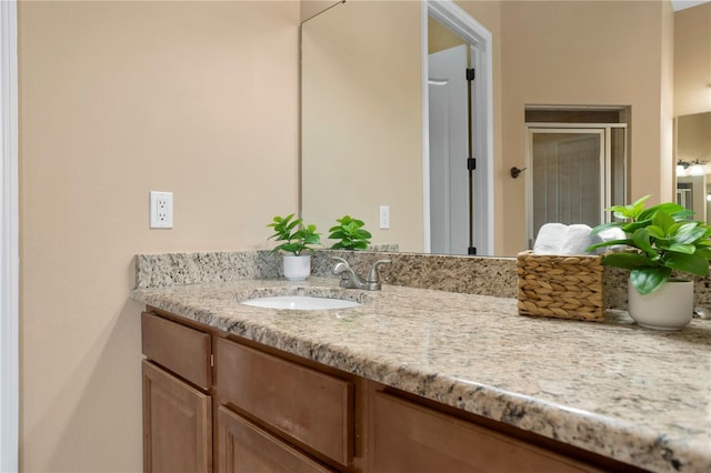 bathroom with a shower stall and vanity