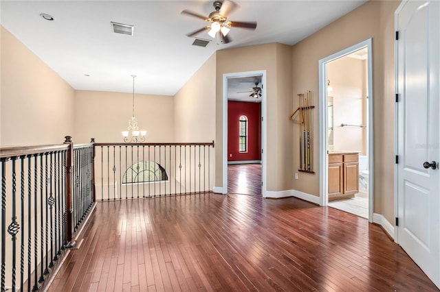 hallway with baseboards, visible vents, a notable chandelier, and dark wood-type flooring