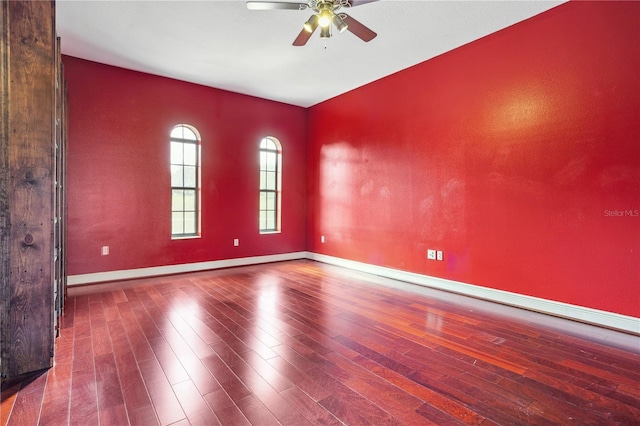 unfurnished room with baseboards, wood finished floors, and a ceiling fan