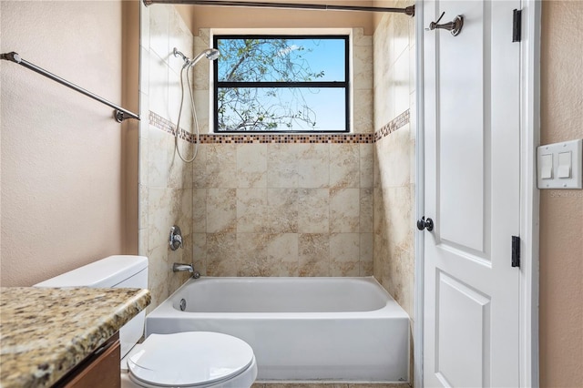 bathroom featuring toilet, shower / bath combination, a textured wall, and vanity