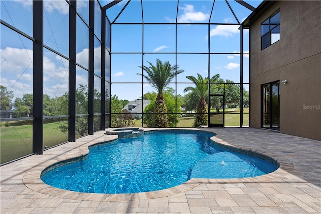 view of pool with a pool with connected hot tub, a patio, and glass enclosure