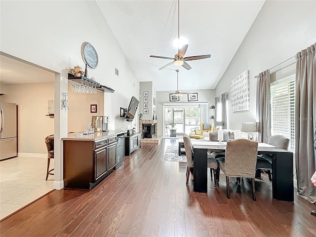 419 Newton Pl, Longwood, FL 32779 - dining area featuring a fireplace with raised hearth, ceiling fan, wood finished floors, and plenty of natural light