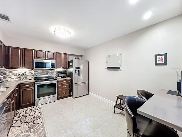 419 Newton Pl, Longwood, FL 32779 - kitchen featuring decorative backsplash, dark brown cabinetry, visible vents, and appliances with stainless steel finishes