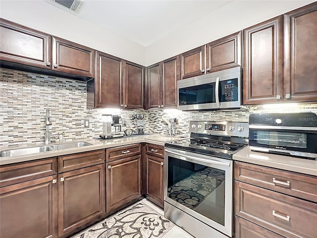 419 Newton Pl, Longwood, FL 32779 - kitchen featuring light countertops, dark brown cabinetry, a sink, backsplash, and appliances with stainless steel finishes