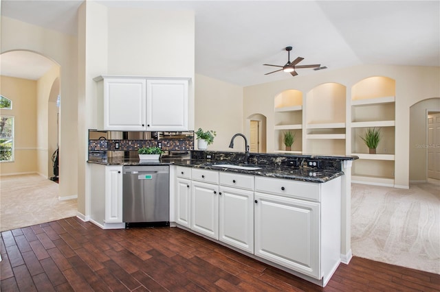 kitchen featuring a sink, a ceiling fan, a peninsula, stainless steel dishwasher, and arched walkways