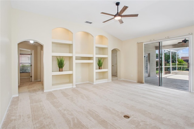 unfurnished living room featuring built in features, ceiling fan, visible vents, and arched walkways