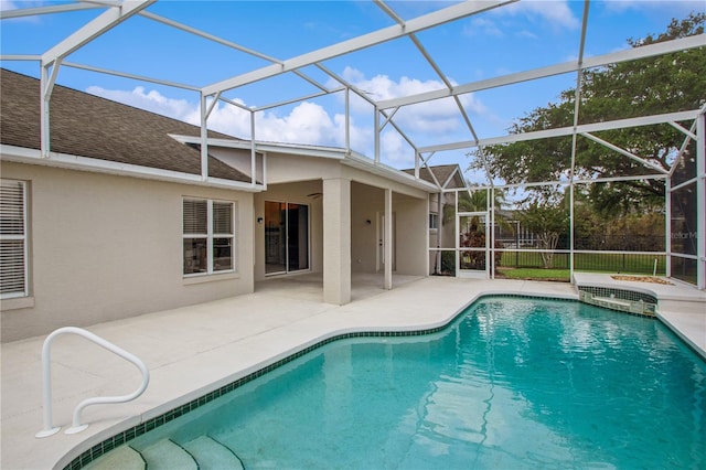 pool with a patio and glass enclosure