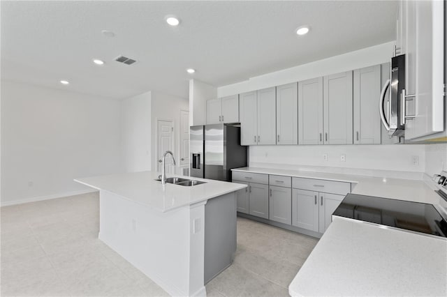 503 Silver Palm Dr, Haines City, FL 33844 - kitchen featuring stainless steel appliances, an island with sink, recessed lighting, gray cabinetry, and light countertops