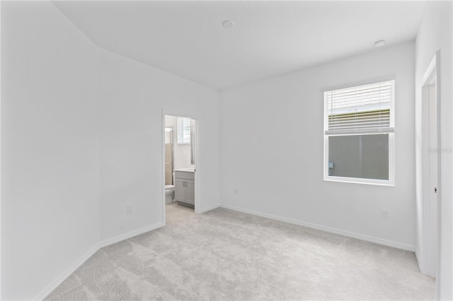 503 Silver Palm Dr, Haines City, FL 33844 - unfurnished bedroom featuring light carpet, multiple windows, and connected bathroom