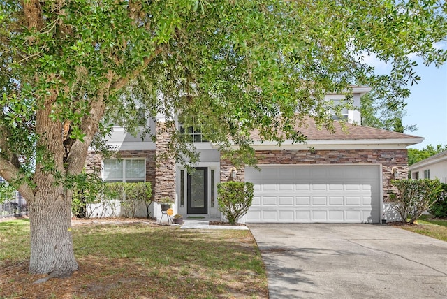 obstructed view of property with concrete driveway, stone siding, a garage, and a front lawn