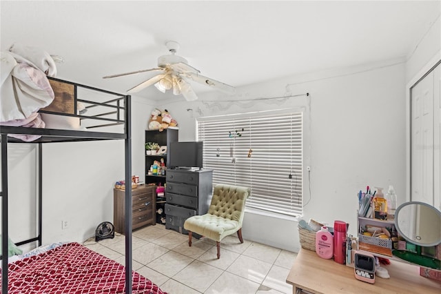 bedroom featuring light tile patterned floors, a ceiling fan, and a closet