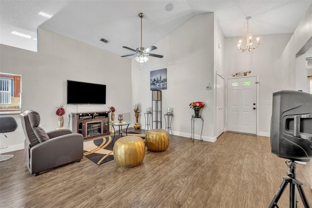 280 Bay St, Apopka, FL 32712 - living area featuring ceiling fan with notable chandelier, high vaulted ceiling, baseboards, visible vents, and wood finished floors