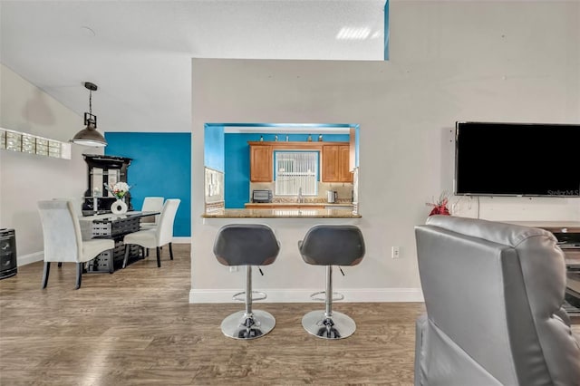 280 Bay St, Apopka, FL 32712 - kitchen with baseboards, a breakfast bar area, wood finished floors, and a sink