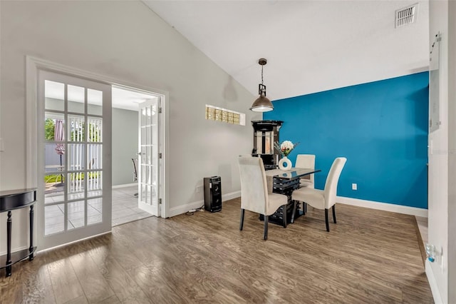 280 Bay St, Apopka, FL 32712 - dining room with an accent wall, wood finished floors, lofted ceiling, baseboards, and visible vents