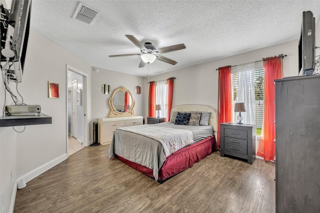 280 Bay St, Apopka, FL 32712 - bedroom featuring baseboards, a textured ceiling, visible vents, a ceiling fan, and wood finished floors