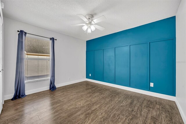 280 Bay St, Apopka, FL 32712 - spare room with a ceiling fan, a decorative wall, dark wood-type flooring, and a textured ceiling