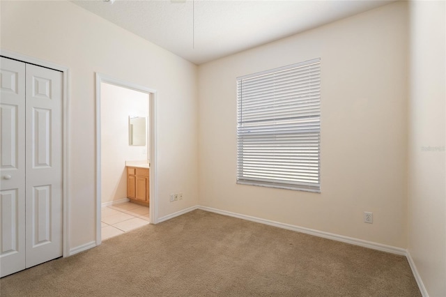 9723 Pecky Cypress Way, Orlando, FL 32836 - unfurnished bedroom featuring light colored carpet, a closet, ensuite bath, and light tile patterned floors
