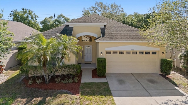 9723 Pecky Cypress Way, Orlando, FL 32836 - view of front of house with stucco siding, an attached garage, concrete driveway, and roof with shingles