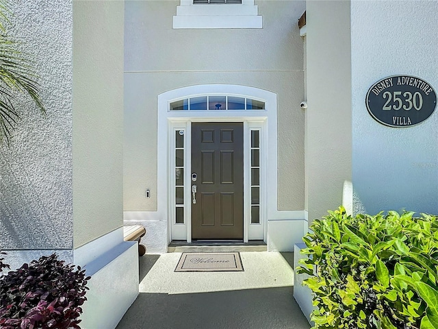 property entrance with stucco siding