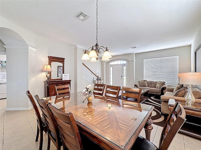 dining room featuring light tile patterned flooring, arched walkways, decorative columns, and visible vents