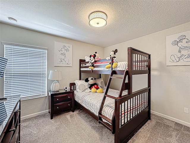 bedroom with carpet flooring, baseboards, and a textured ceiling