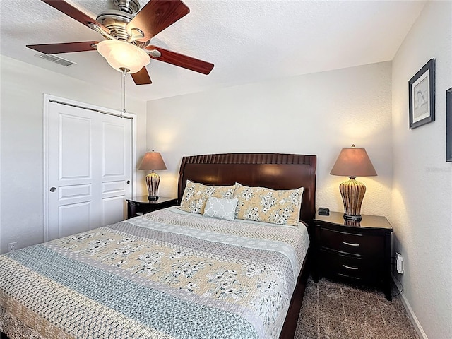 carpeted bedroom with a closet, baseboards, a ceiling fan, and visible vents