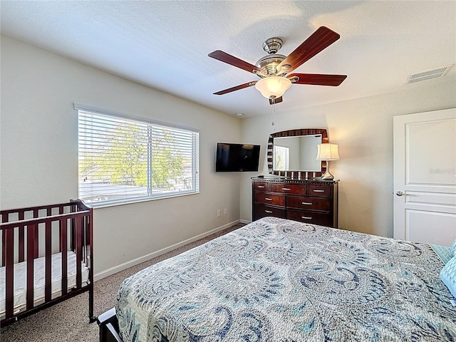 carpeted bedroom featuring visible vents, baseboards, and a ceiling fan