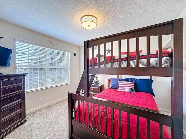 bedroom featuring a textured ceiling, baseboards, and carpet floors