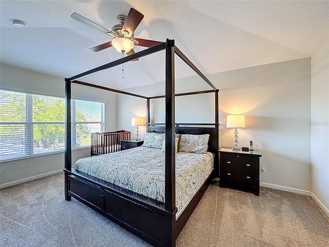 carpeted bedroom with baseboards, a ceiling fan, and vaulted ceiling