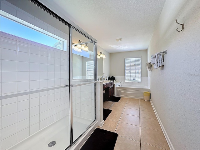 bathroom featuring vanity, tile patterned flooring, a textured ceiling, a shower stall, and a garden tub