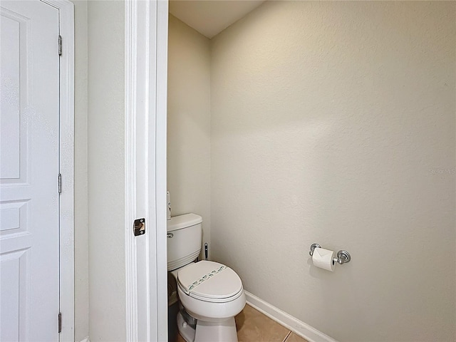 bathroom featuring tile patterned floors, baseboards, and toilet