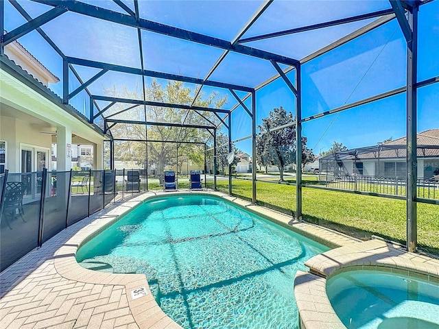 view of swimming pool with a yard, a patio area, a pool with connected hot tub, a ceiling fan, and a lanai