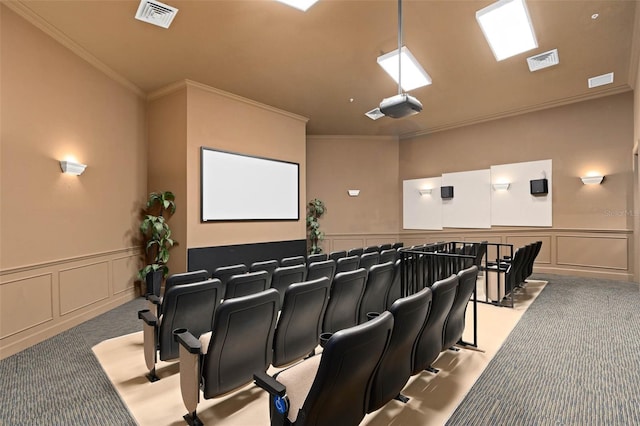 carpeted cinema with a decorative wall, visible vents, and ornamental molding