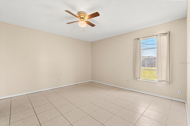 spare room featuring ceiling fan, baseboards, a textured ceiling, and light tile patterned floors